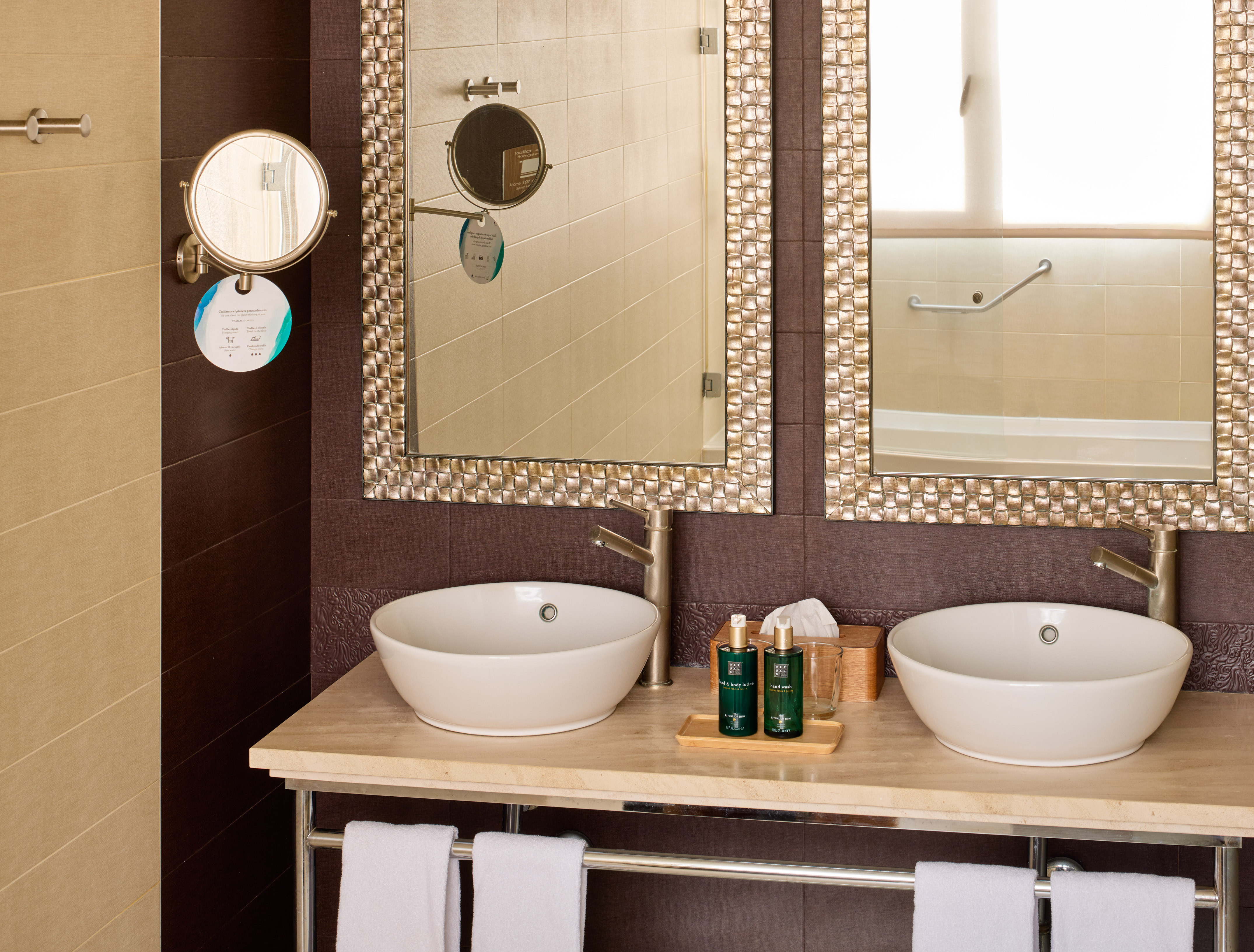 Luxury bathroom vanity with double sinks, ornate mirrors, and hotel toiletries.