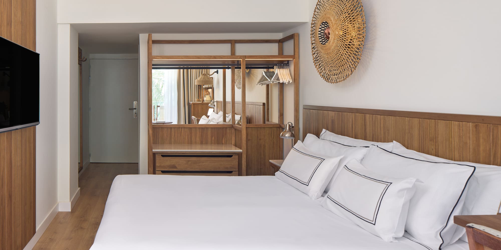 a bed with white sheets and a mirror above it