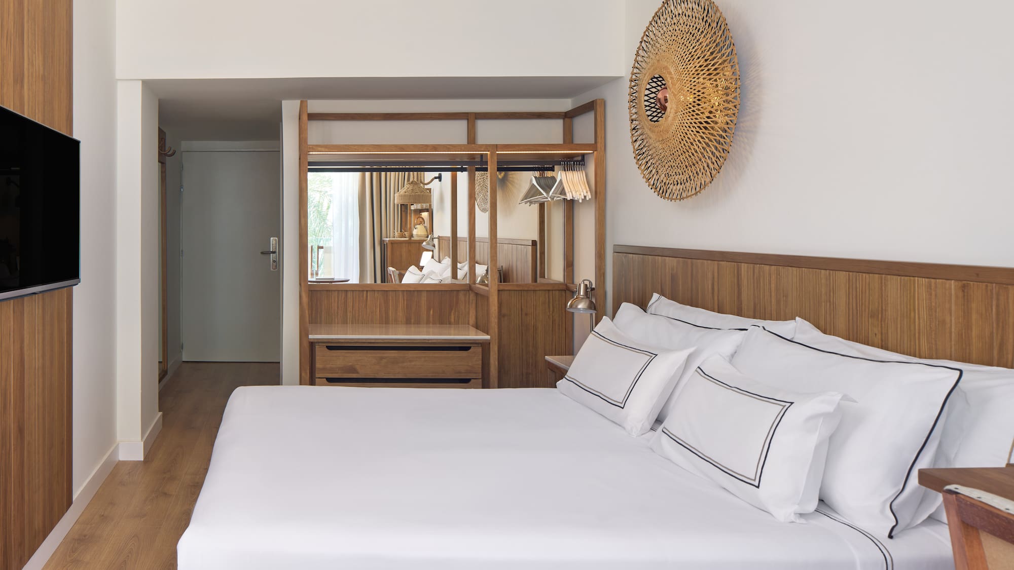 a bed with white sheets and a mirror above it