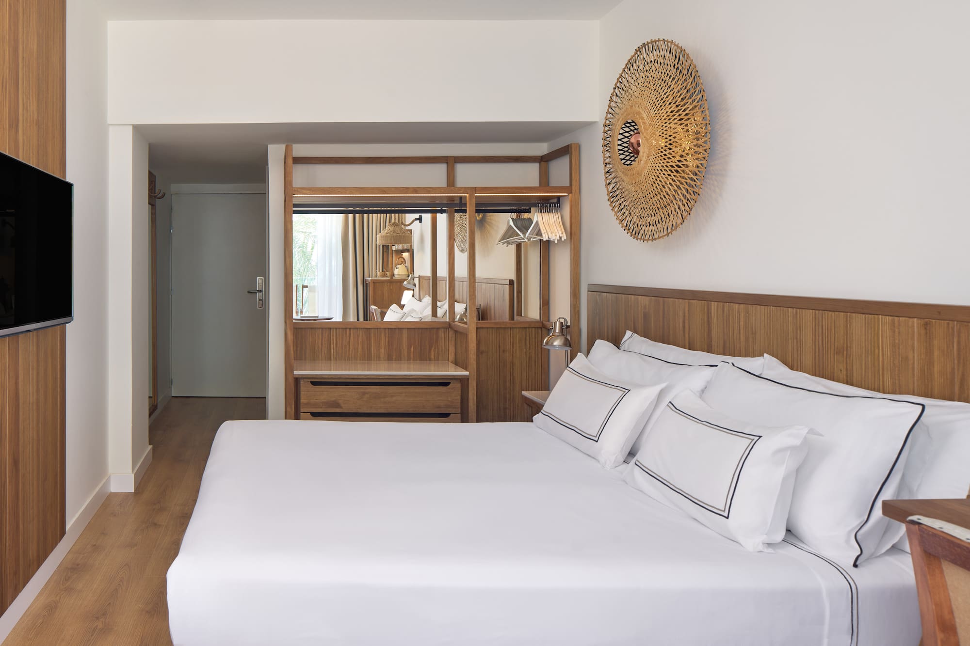 a bed with white sheets and a mirror above it