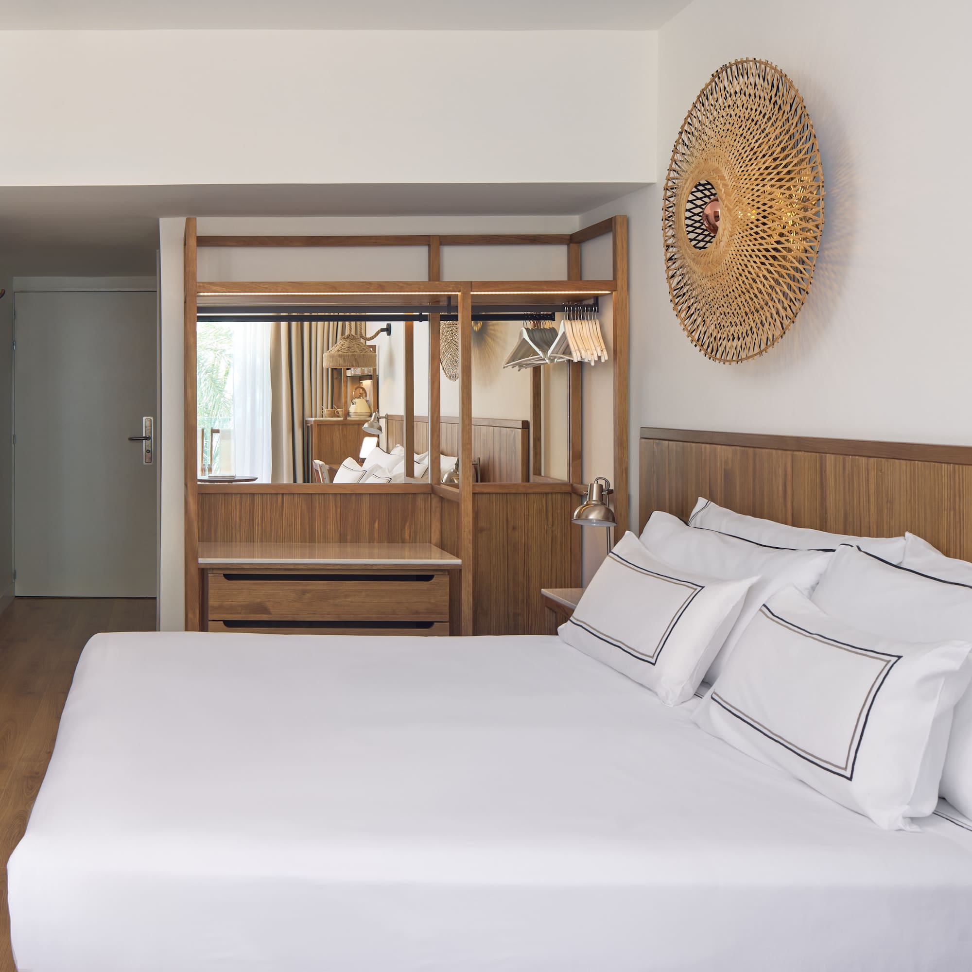 a bed with white sheets and a mirror above it