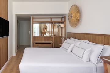 a bed with white sheets and a mirror above it