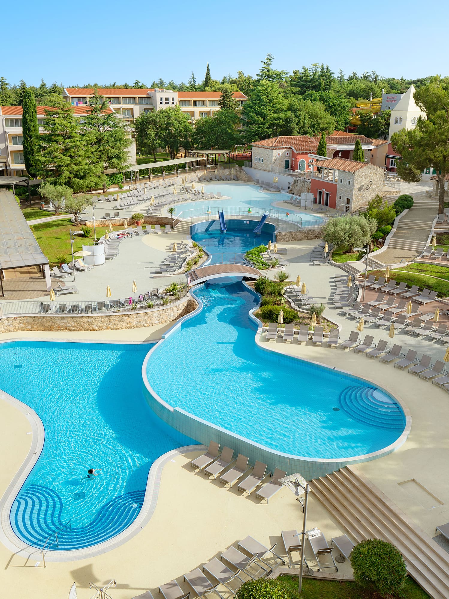 a swimming pool with chairs and trees