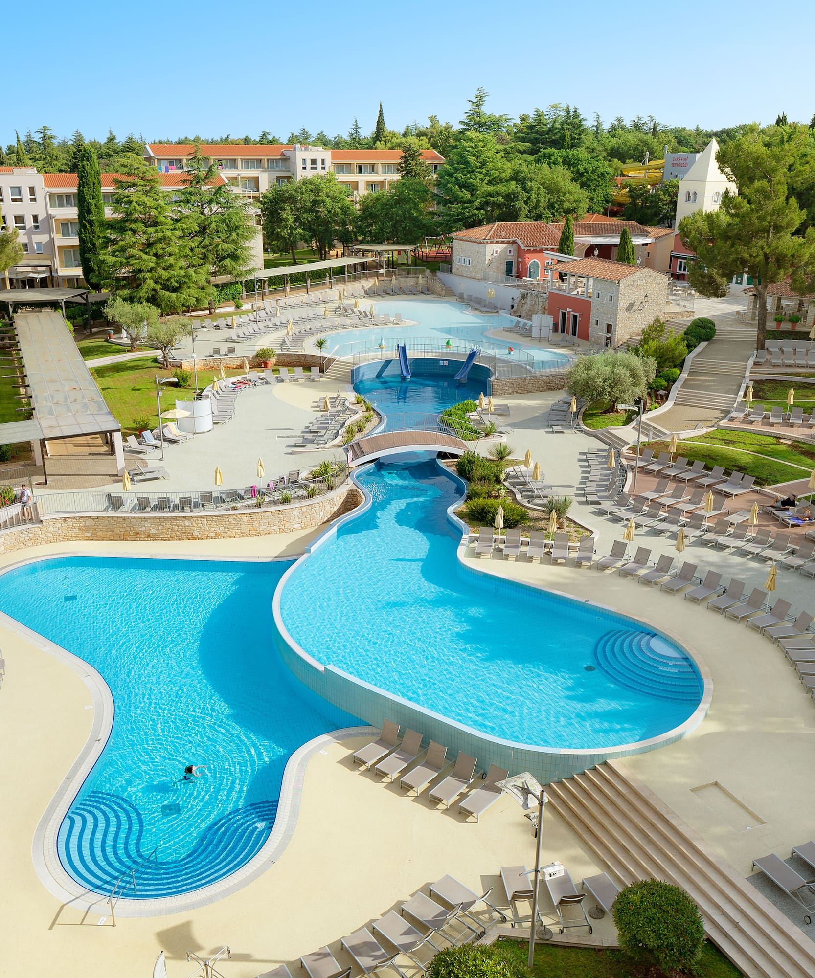 a swimming pool with chairs and trees