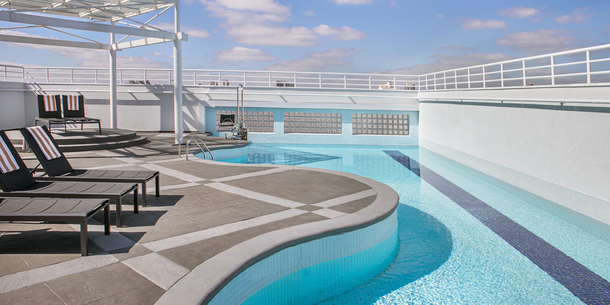 a pool with a deck and chairs
