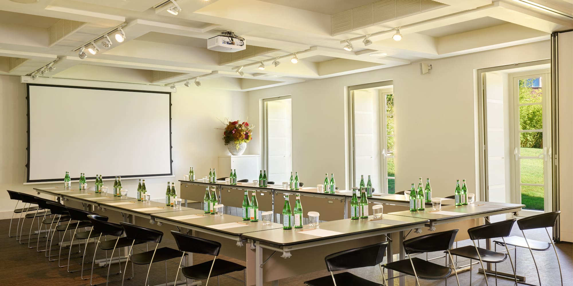 a room with a white board and tables with bottles of beer