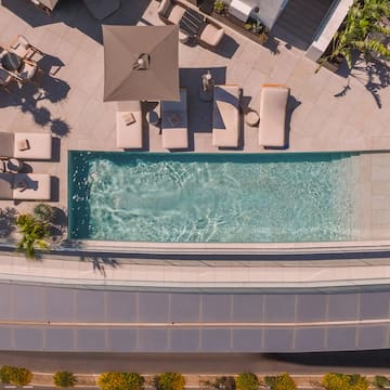 a pool with lounge chairs and a roof