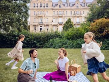 a group of people on a picnic blanket in a park