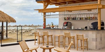 a bar with chairs and a table on a deck