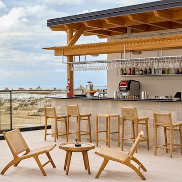 a bar with chairs and a table on a deck