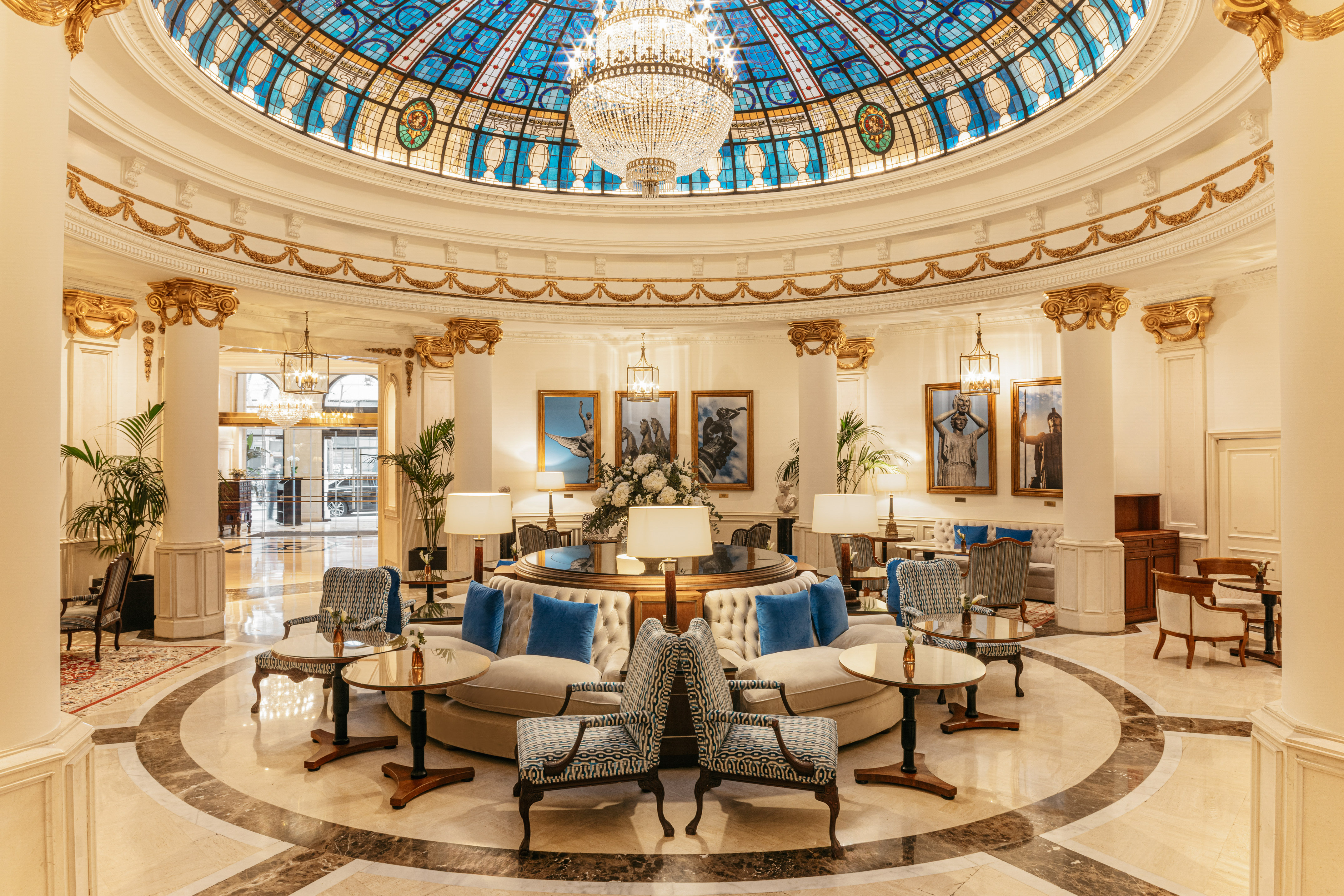 Elegant hotel lobby with a grand stained glass dome and crystal chandelier.