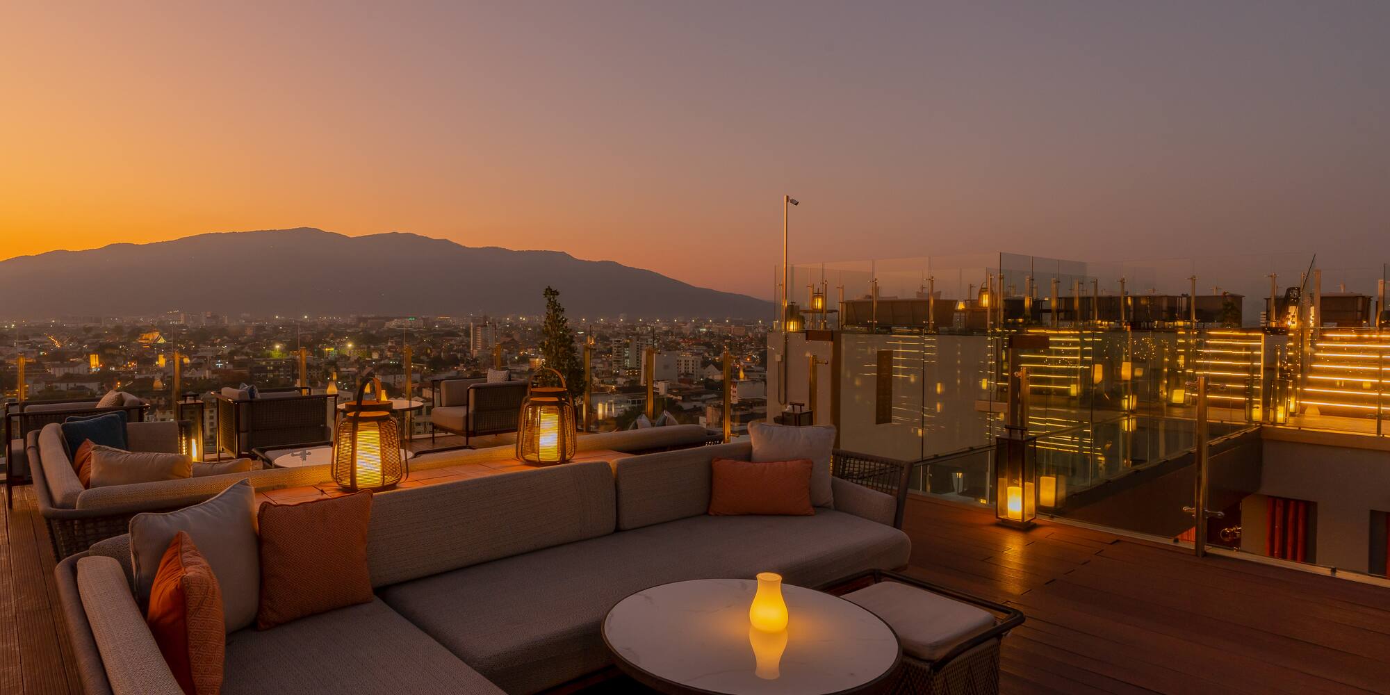 a rooftop patio with a view of a city and mountains