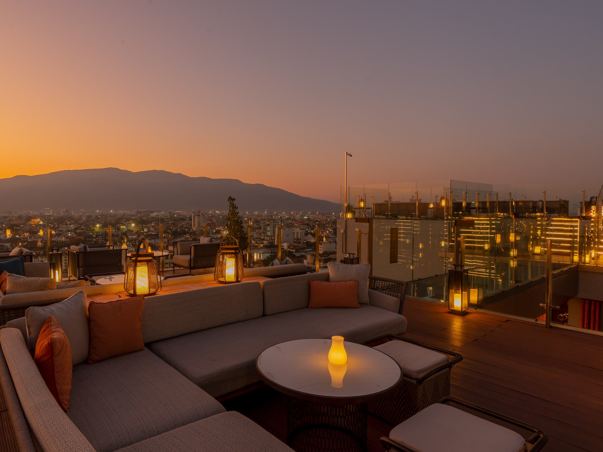 a rooftop patio with a view of a city and mountains