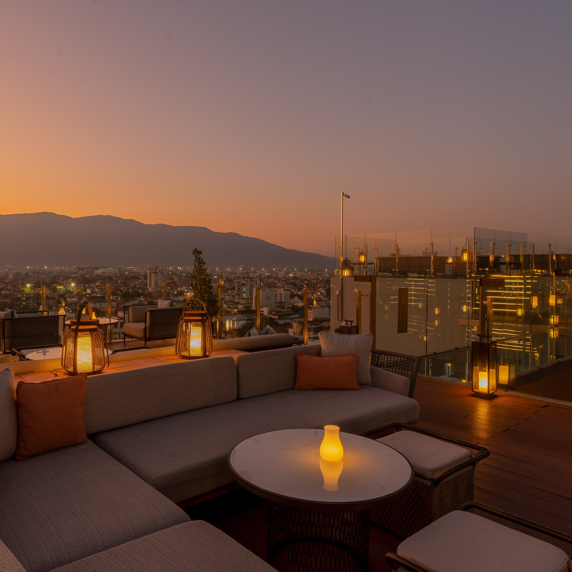 a rooftop patio with a view of a city and mountains