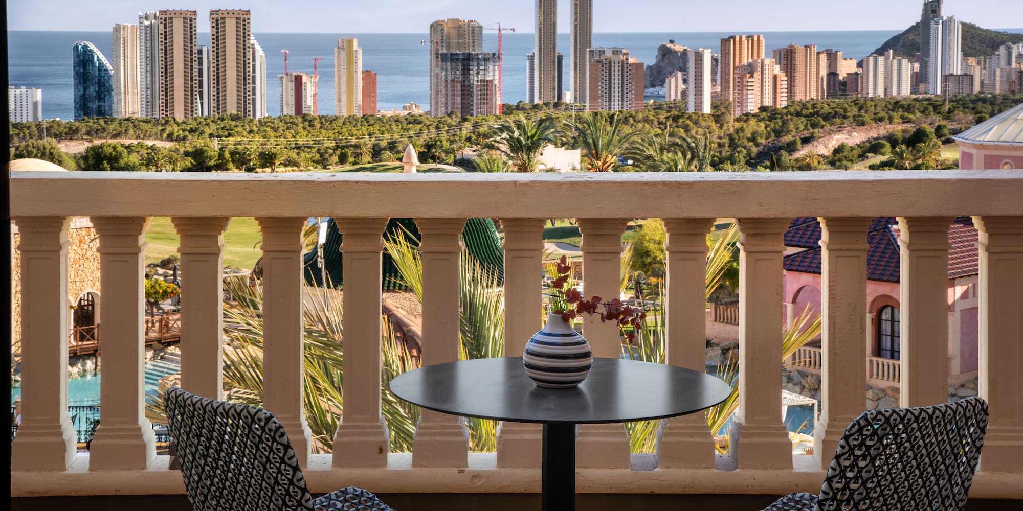 a table and chairs on a balcony overlooking a city