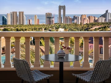 a table and chairs on a balcony overlooking a city