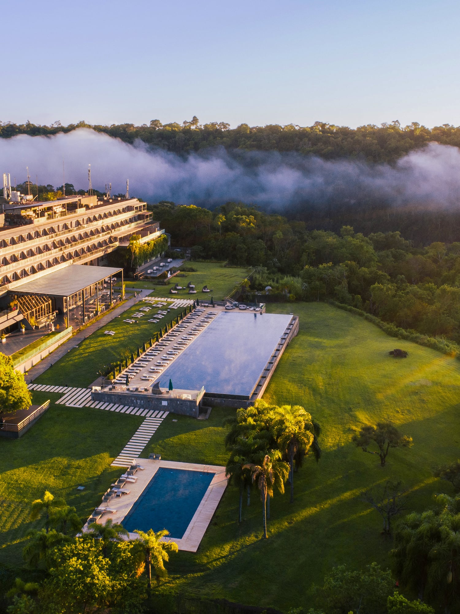 a building with a pool and trees