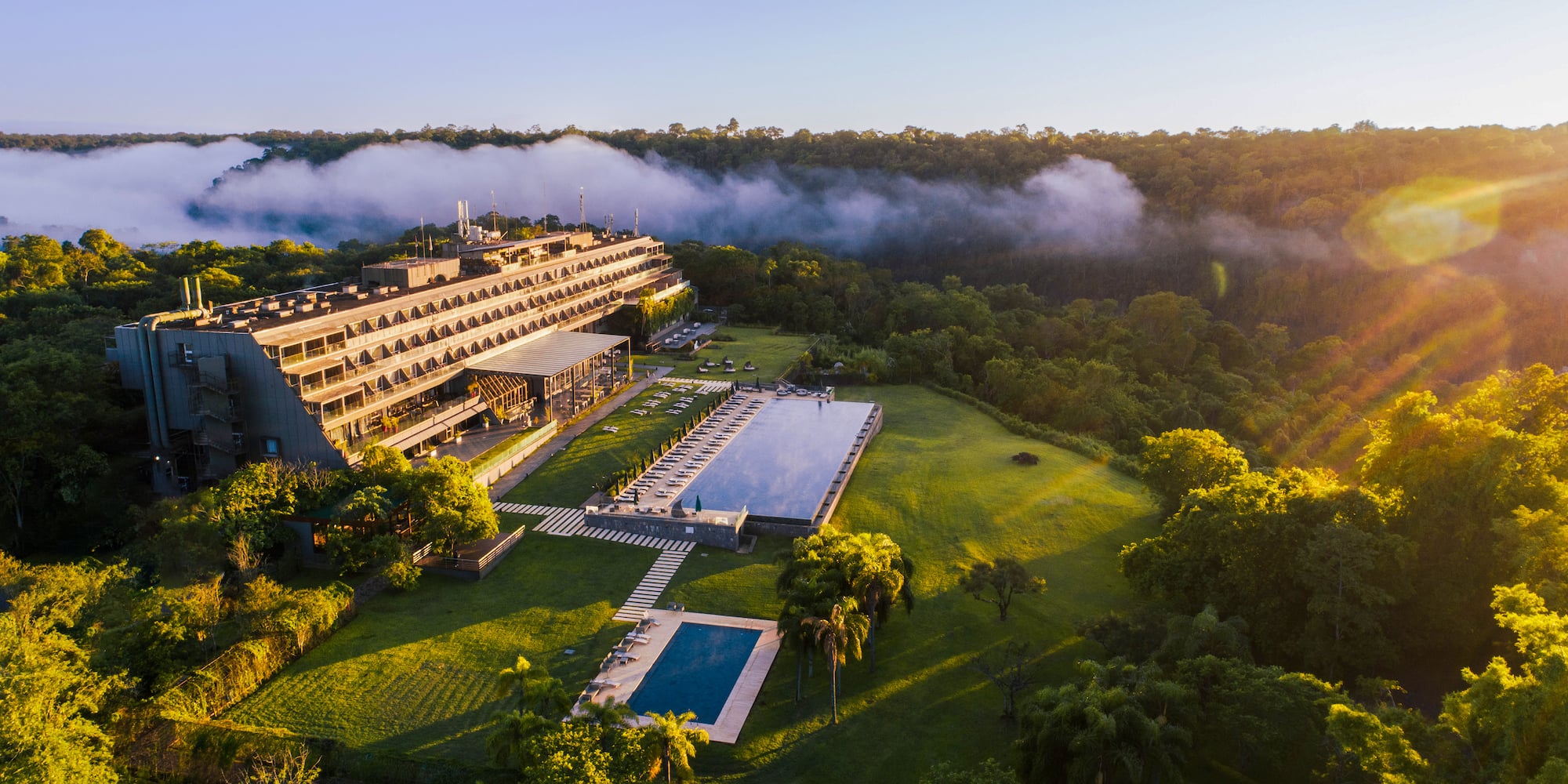a building with a pool and trees
