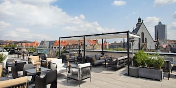 a rooftop patio with chairs and tables