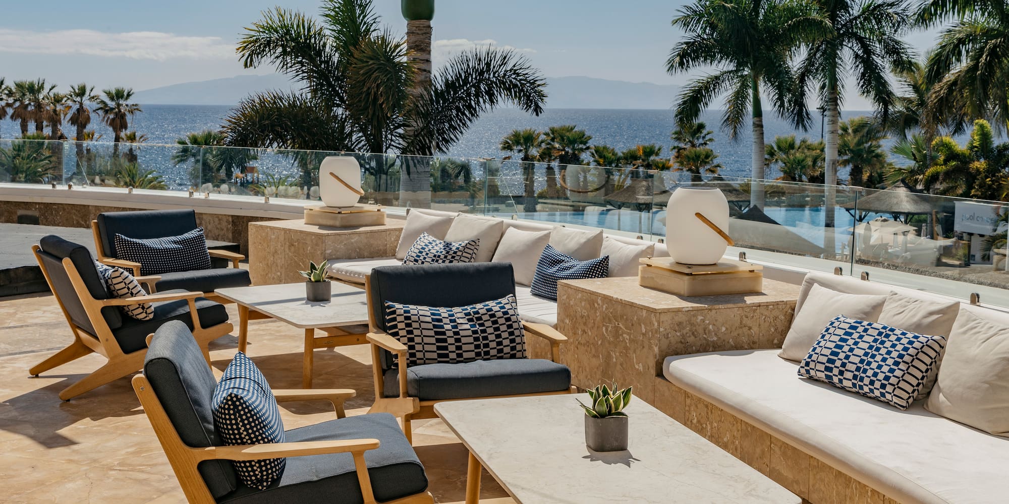 a patio with chairs and tables and palm trees