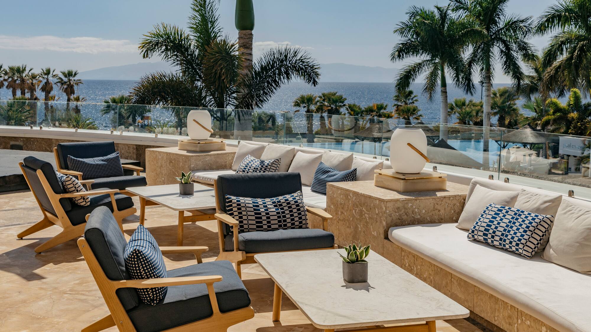 a patio with chairs and tables and palm trees