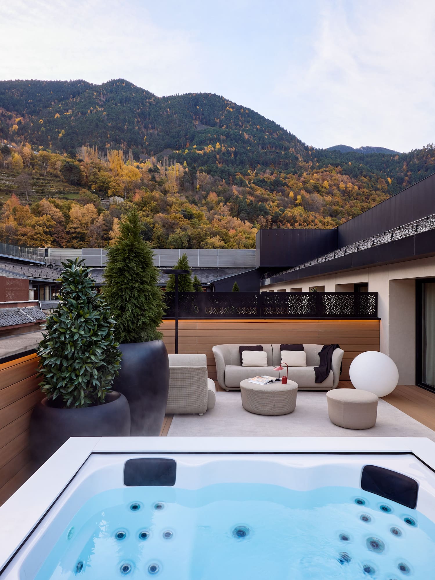 a hot tub on a deck with a mountain in the background