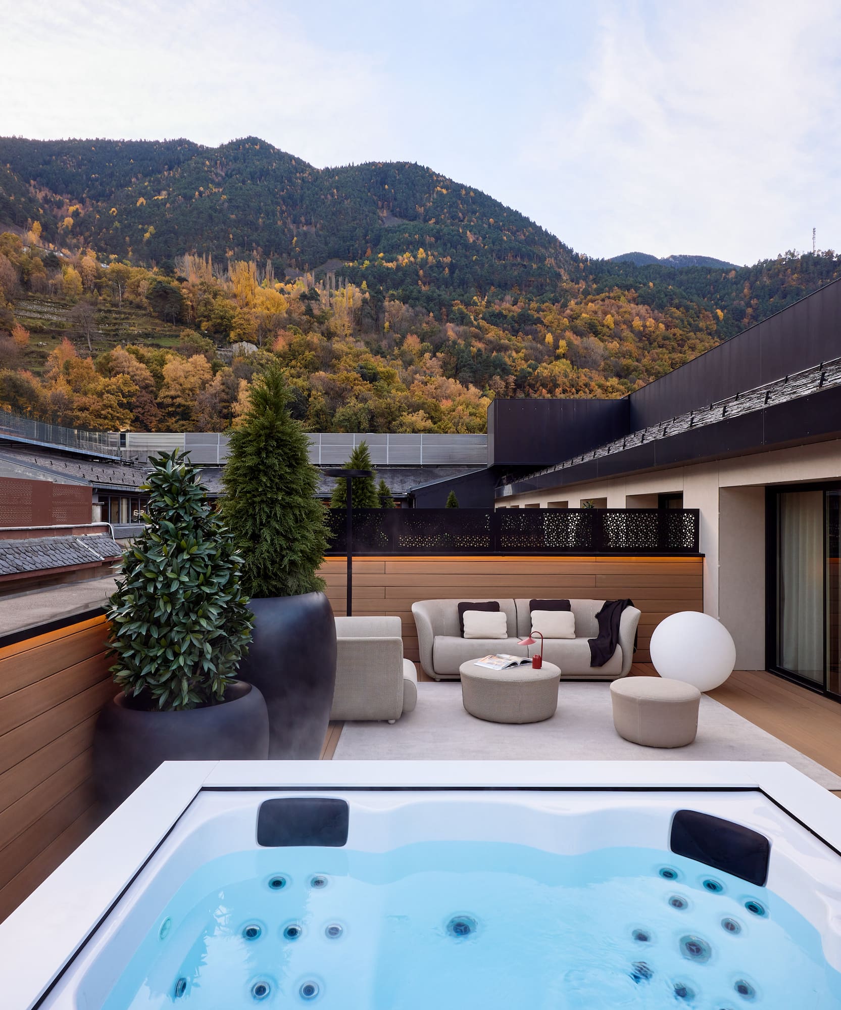 a hot tub on a deck with a mountain in the background