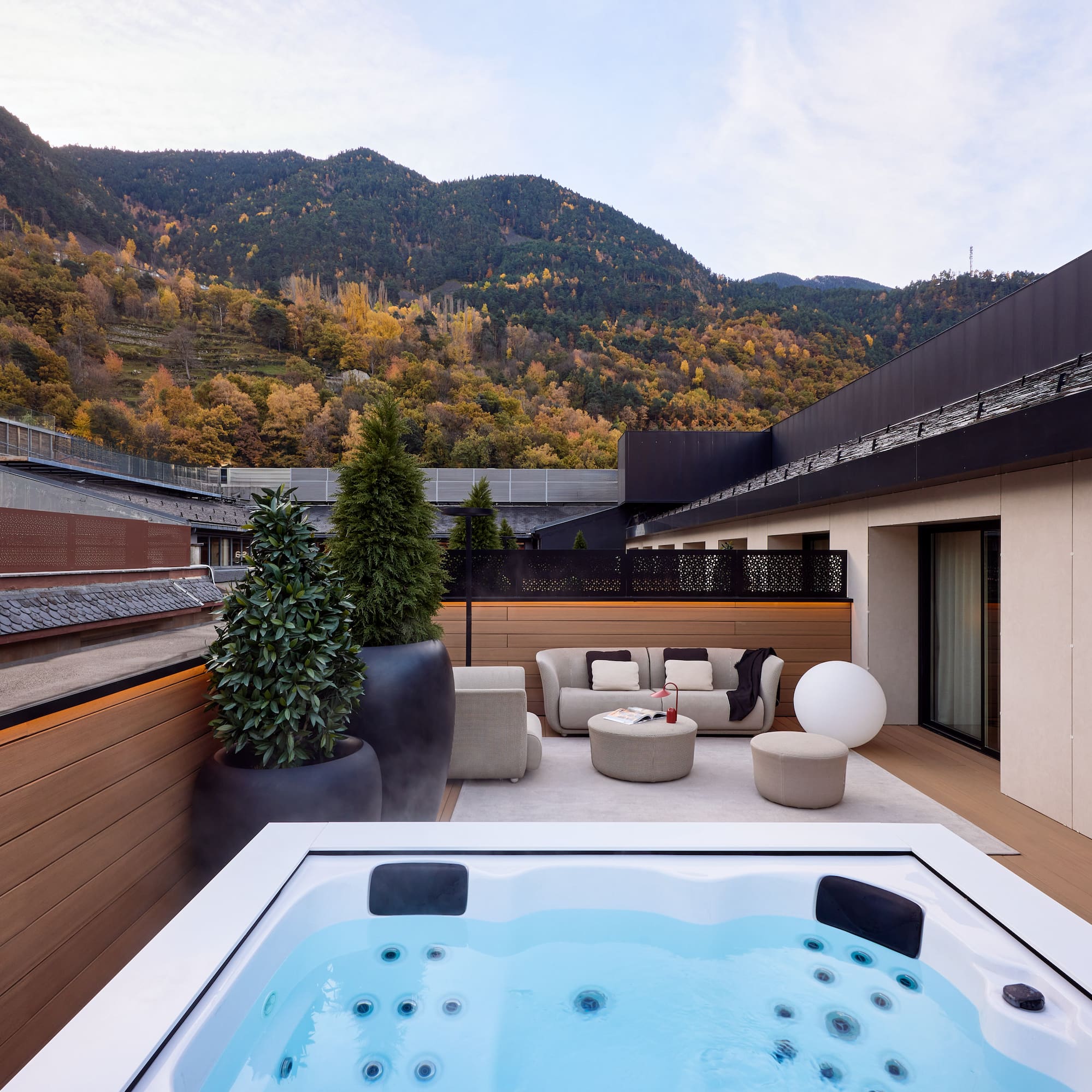 a hot tub on a deck with a mountain in the background