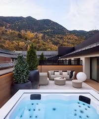 a hot tub on a deck with a mountain in the background