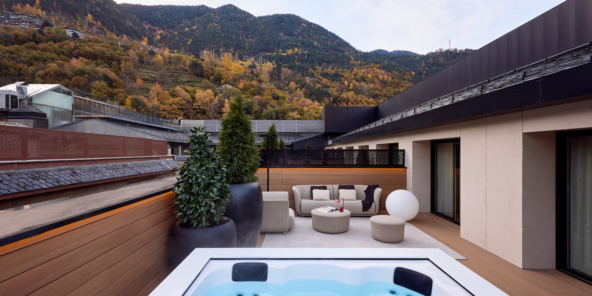a hot tub on a deck with a mountain in the background