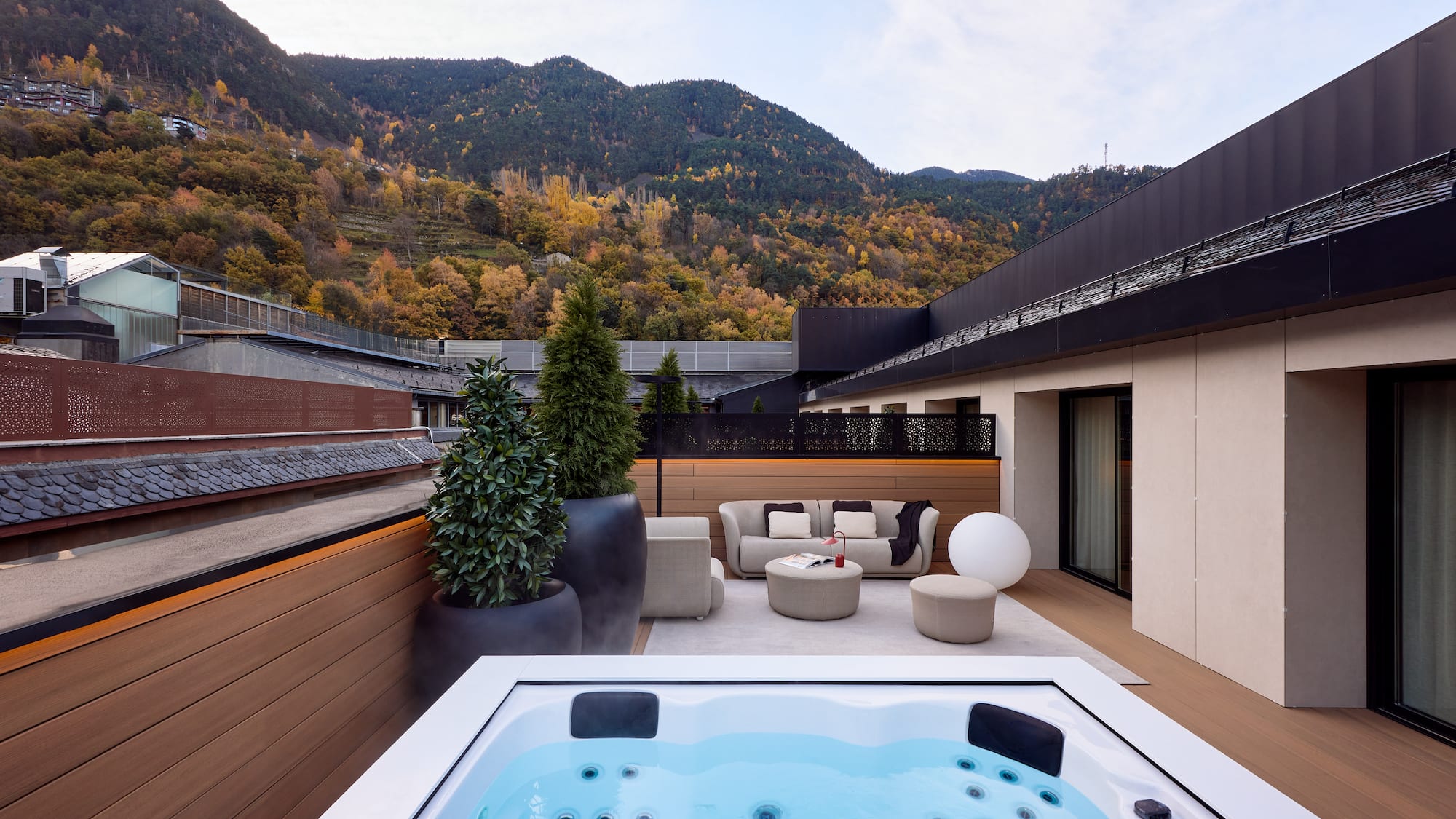 a hot tub on a deck with a mountain in the background