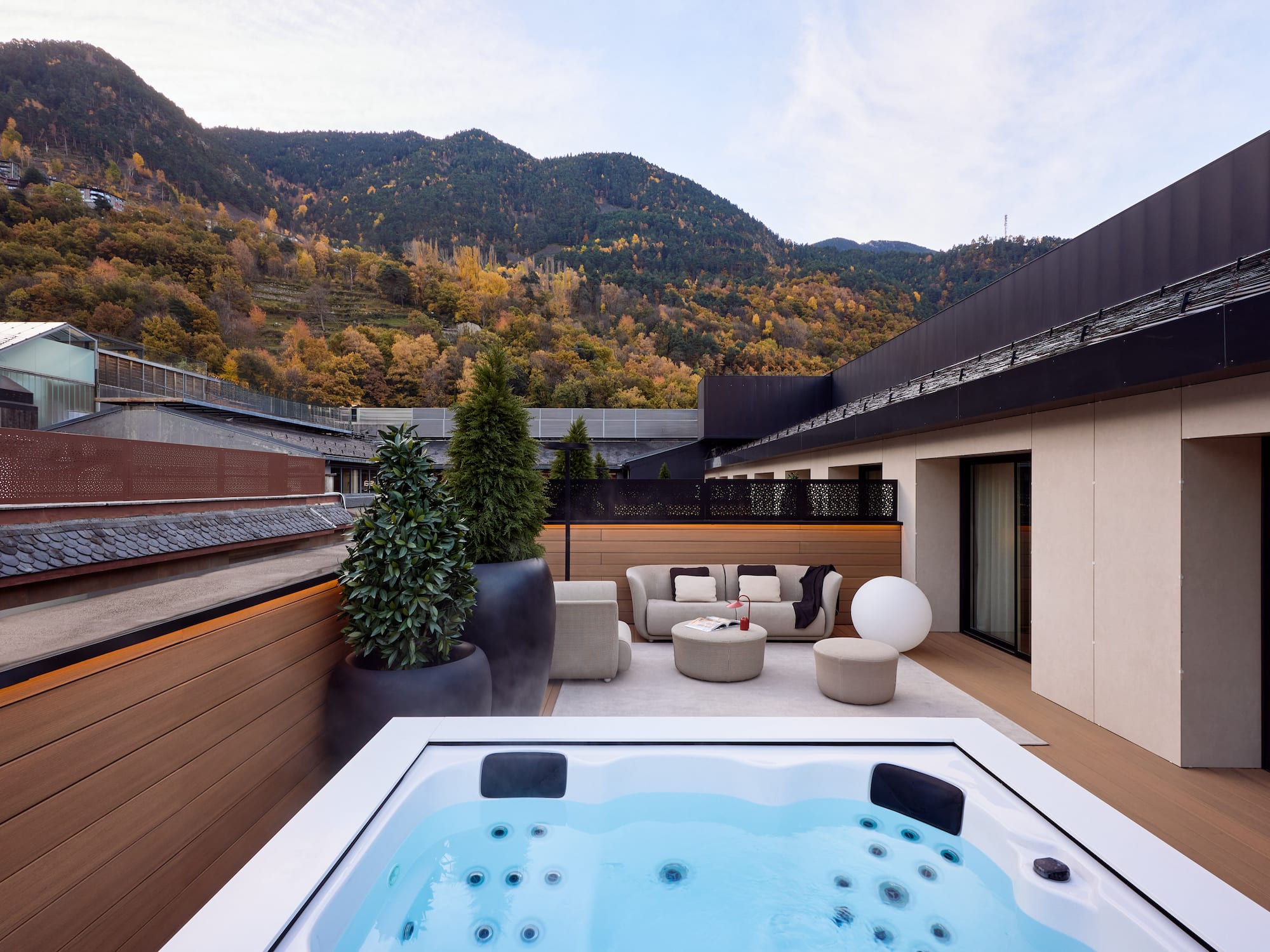 a hot tub on a deck with a mountain in the background
