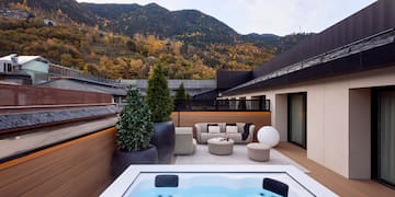 a hot tub on a deck with a mountain in the background