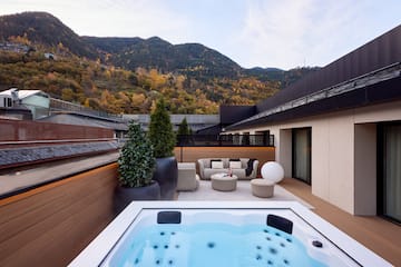 a hot tub on a deck with a mountain in the background