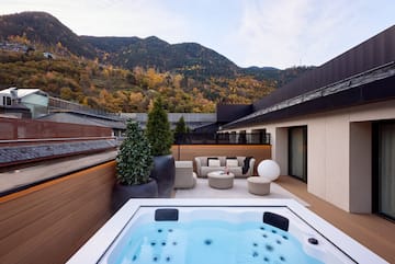 a hot tub on a deck with a mountain in the background
