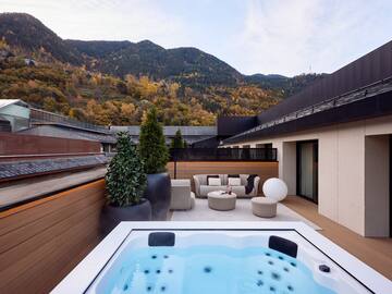 a hot tub on a deck with a mountain in the background