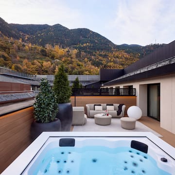 a hot tub on a deck with a mountain in the background