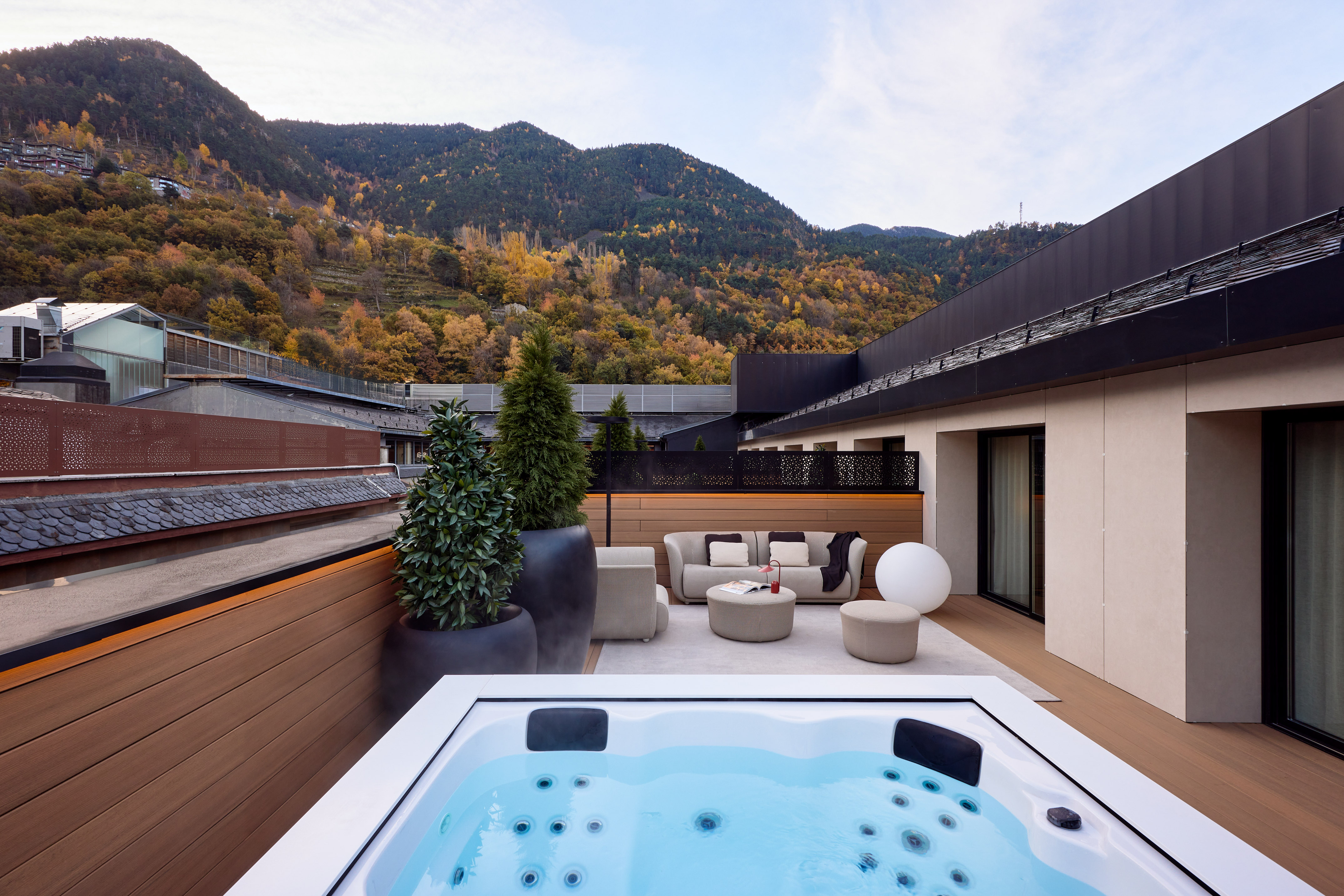 a hot tub on a deck with a mountain in the background