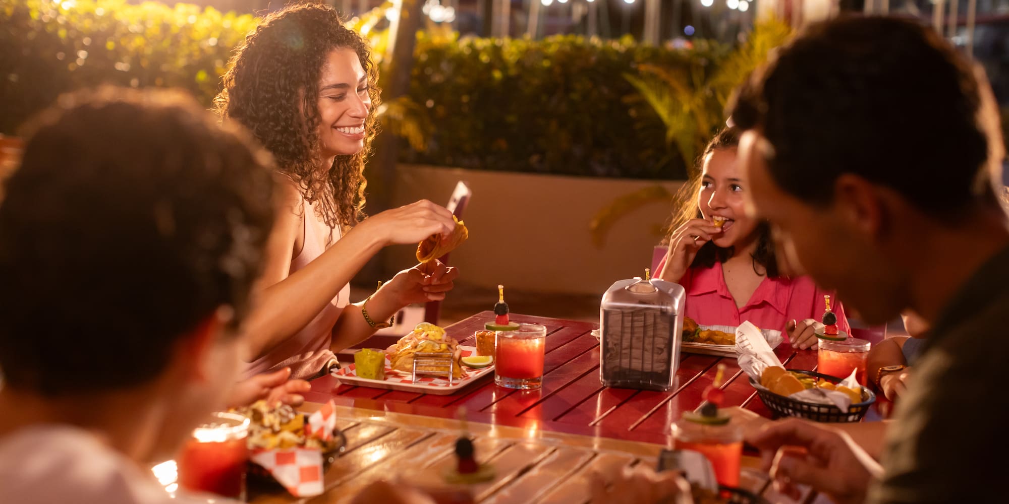 a group of people sitting at a table eating food