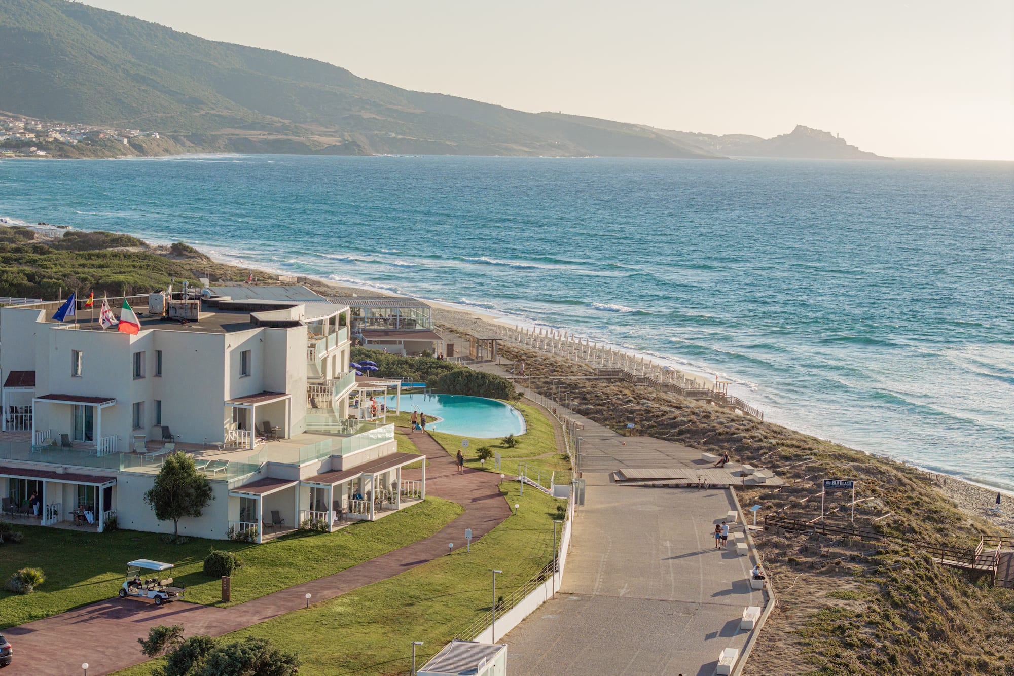 a beach with a building and a pool