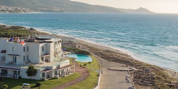 a beach with a building and a pool