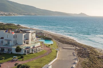 a beach with a building and a pool