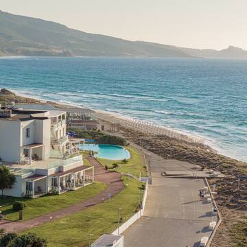 a beach with a building and a pool