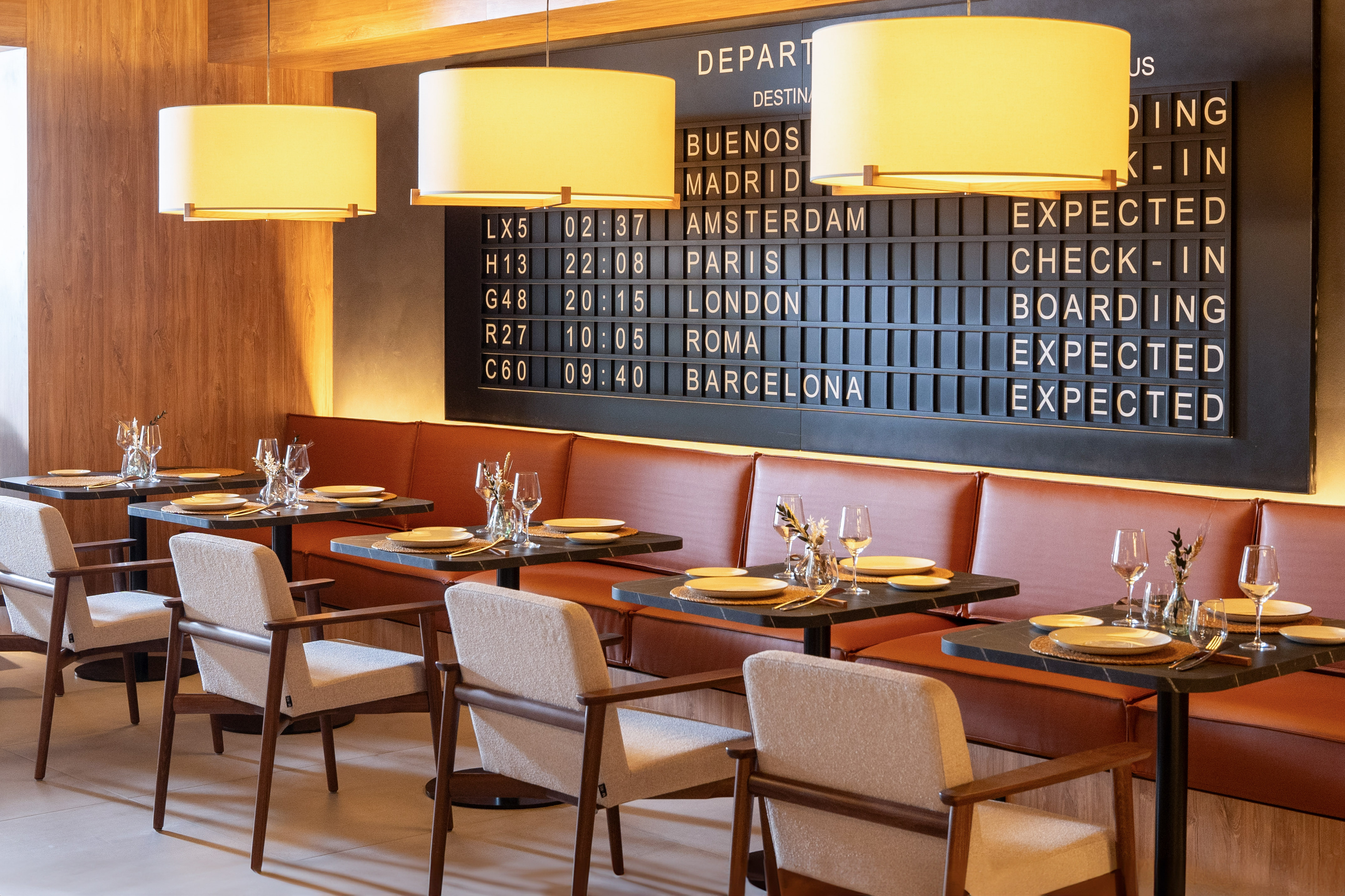 Cafe restaurant with airport departure board, modern tables, and comfortable seating.