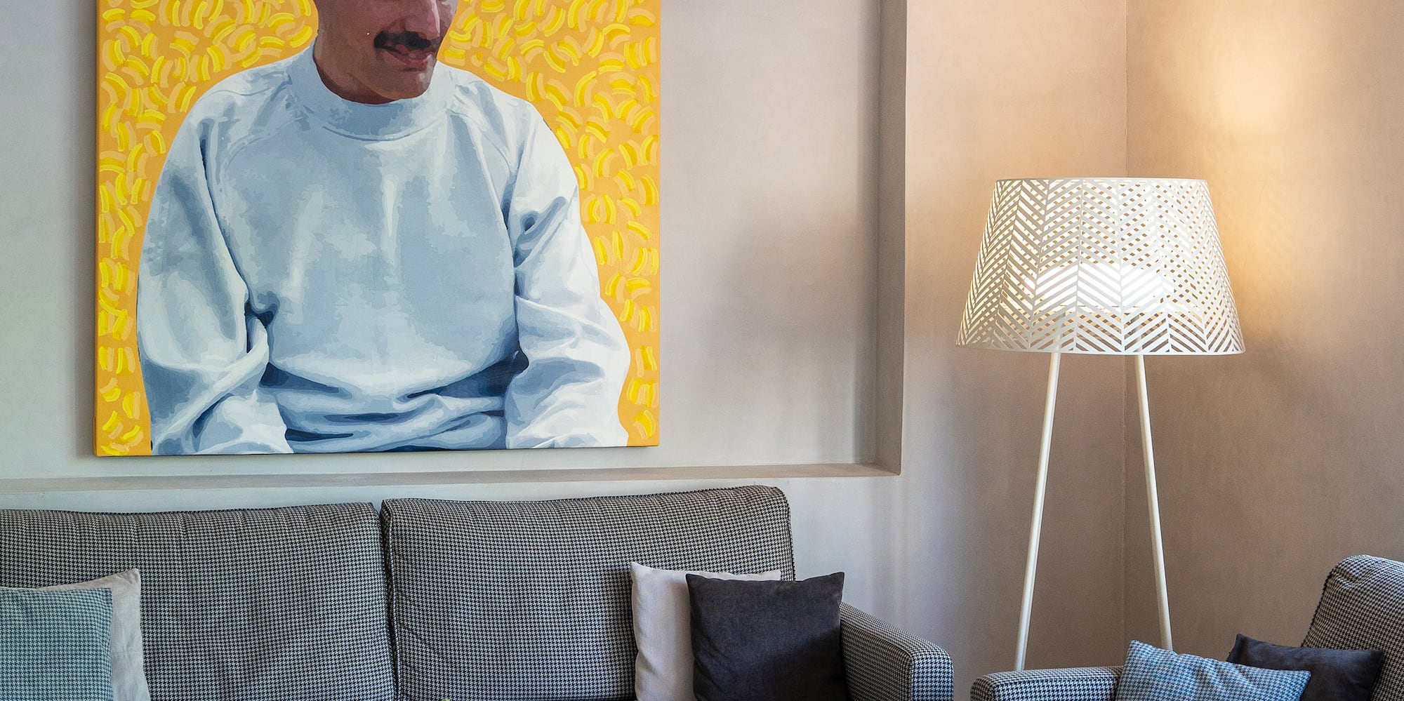 a living room with a couch and a painting of a man