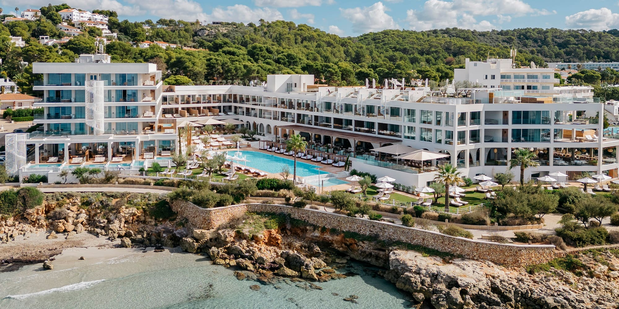 a building with a pool and trees on the side of it