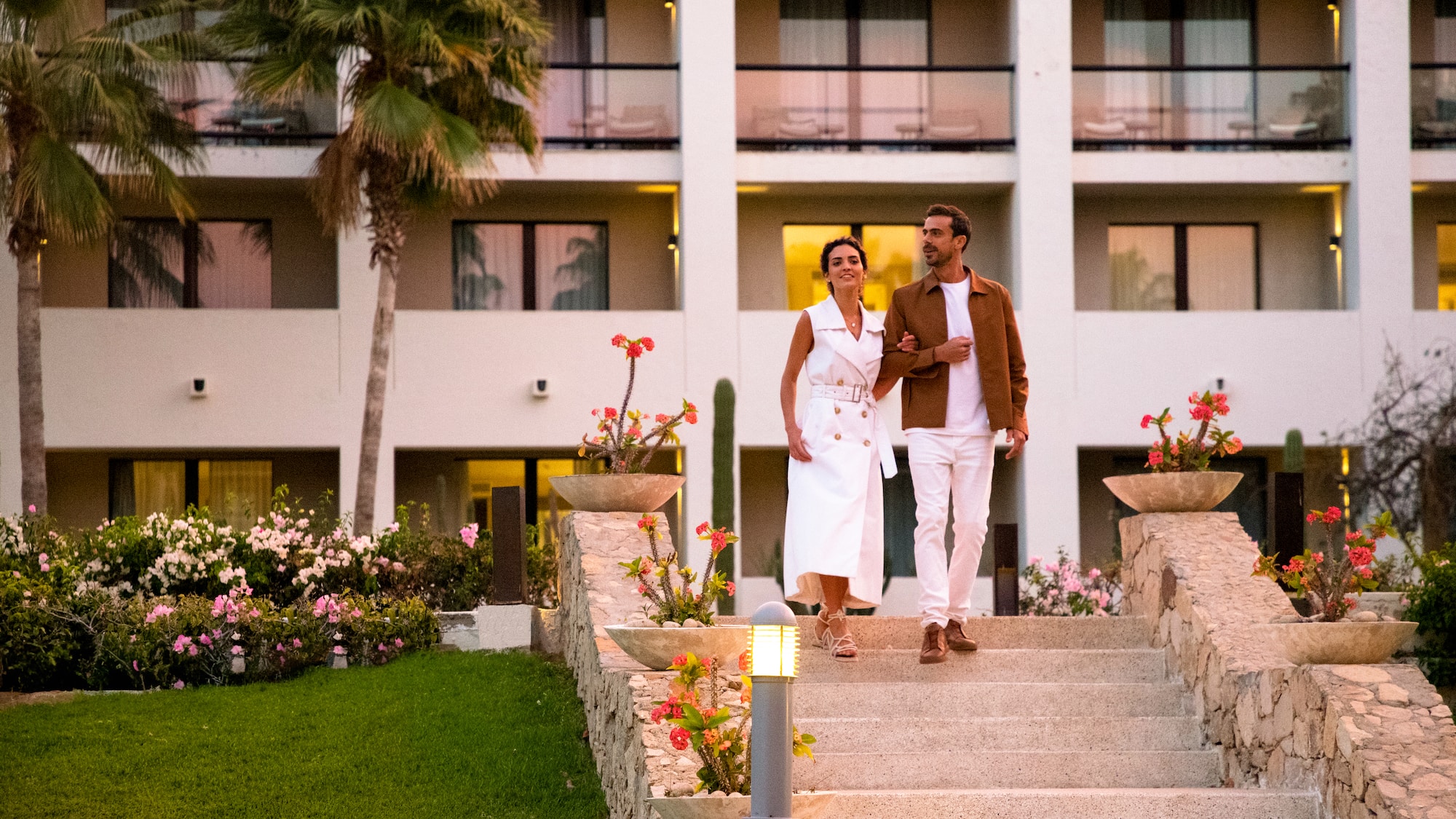 a man and woman walking up stairs in front of a building
