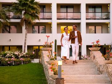 a man and woman walking up stairs in front of a building