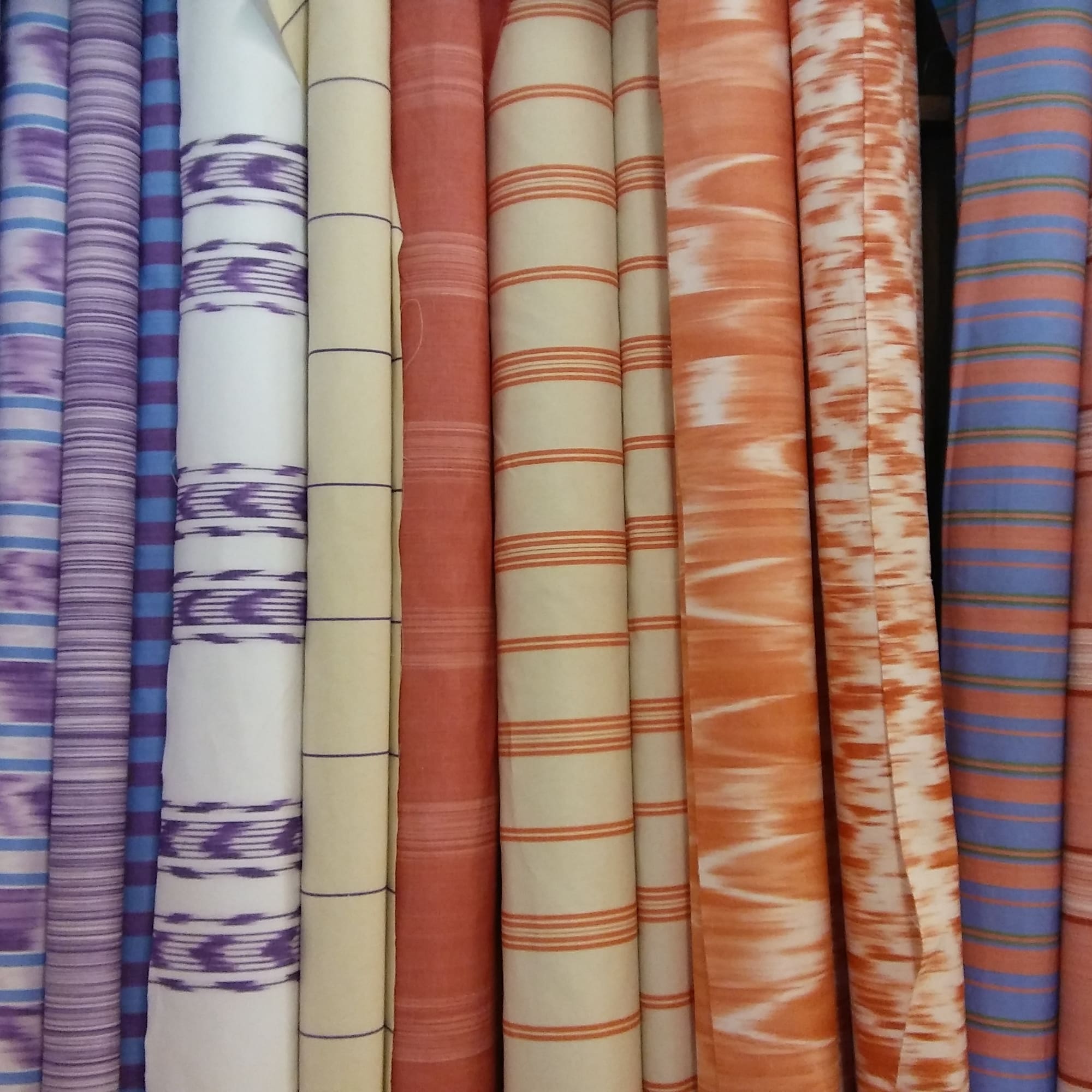 a group of colorful fabric rolls