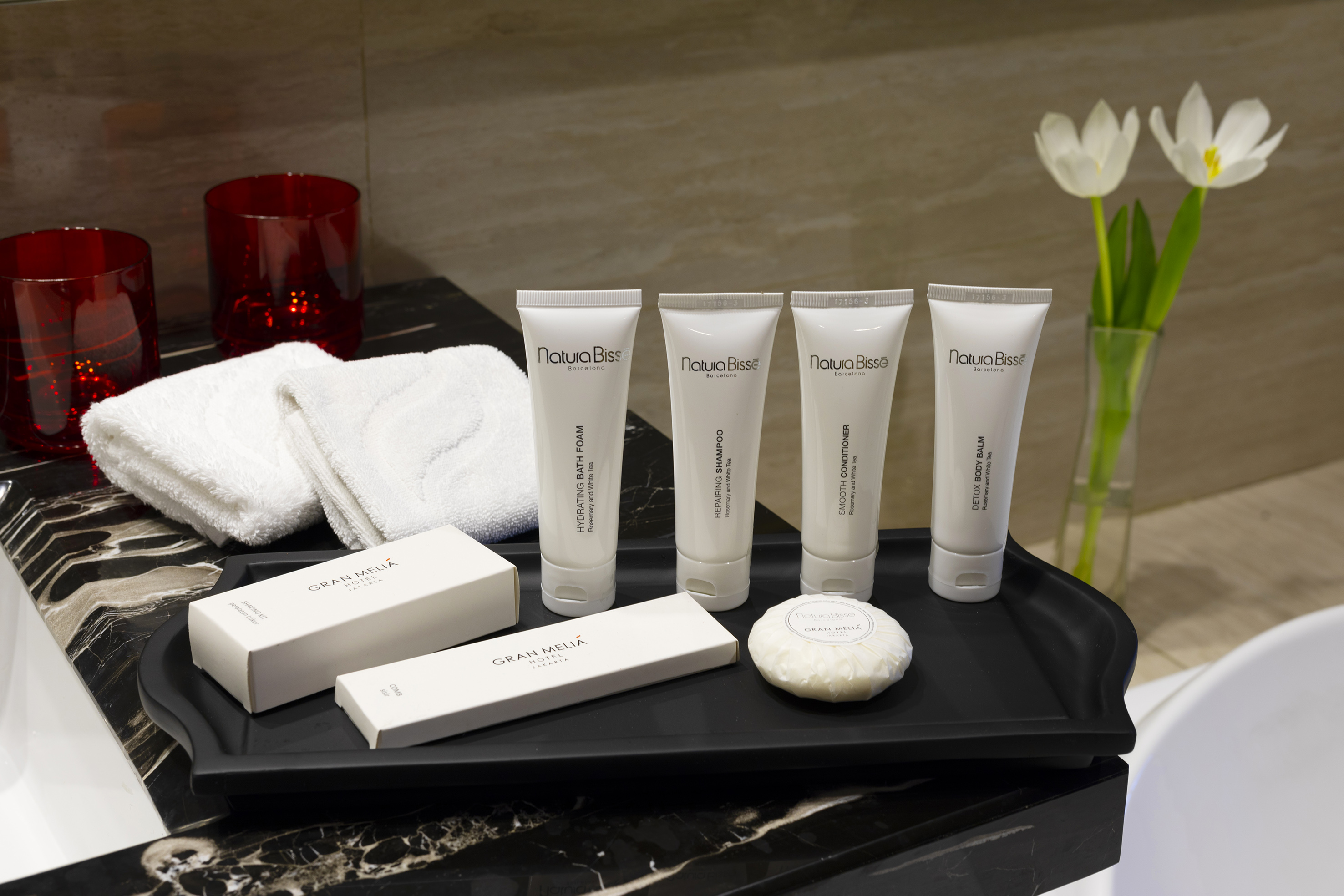 Natura Bisse luxury hotel toiletries: shampoo, conditioner, soap, and towels.